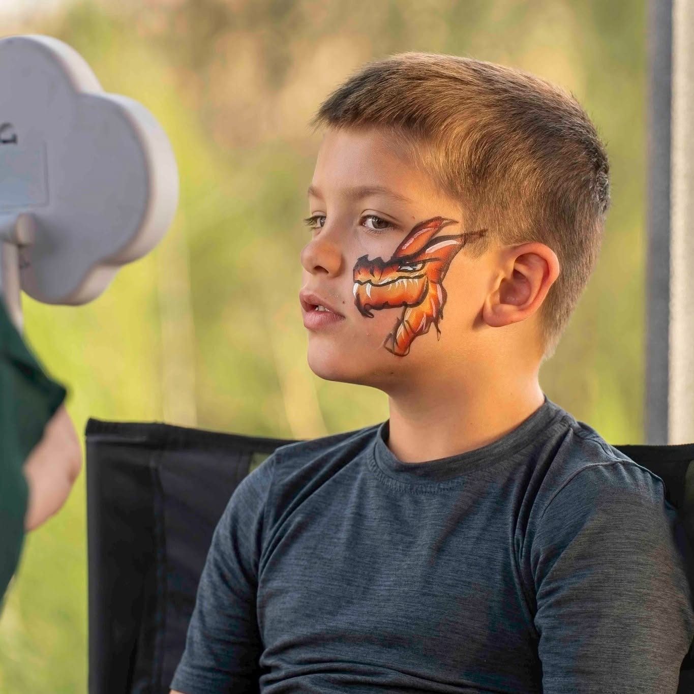 Dragon face paint design at a birthday celebration