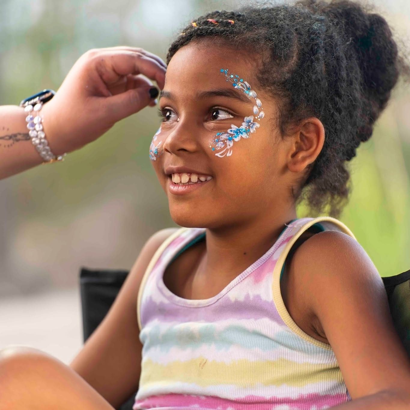 Floral eye design face paint at a birthday celebration